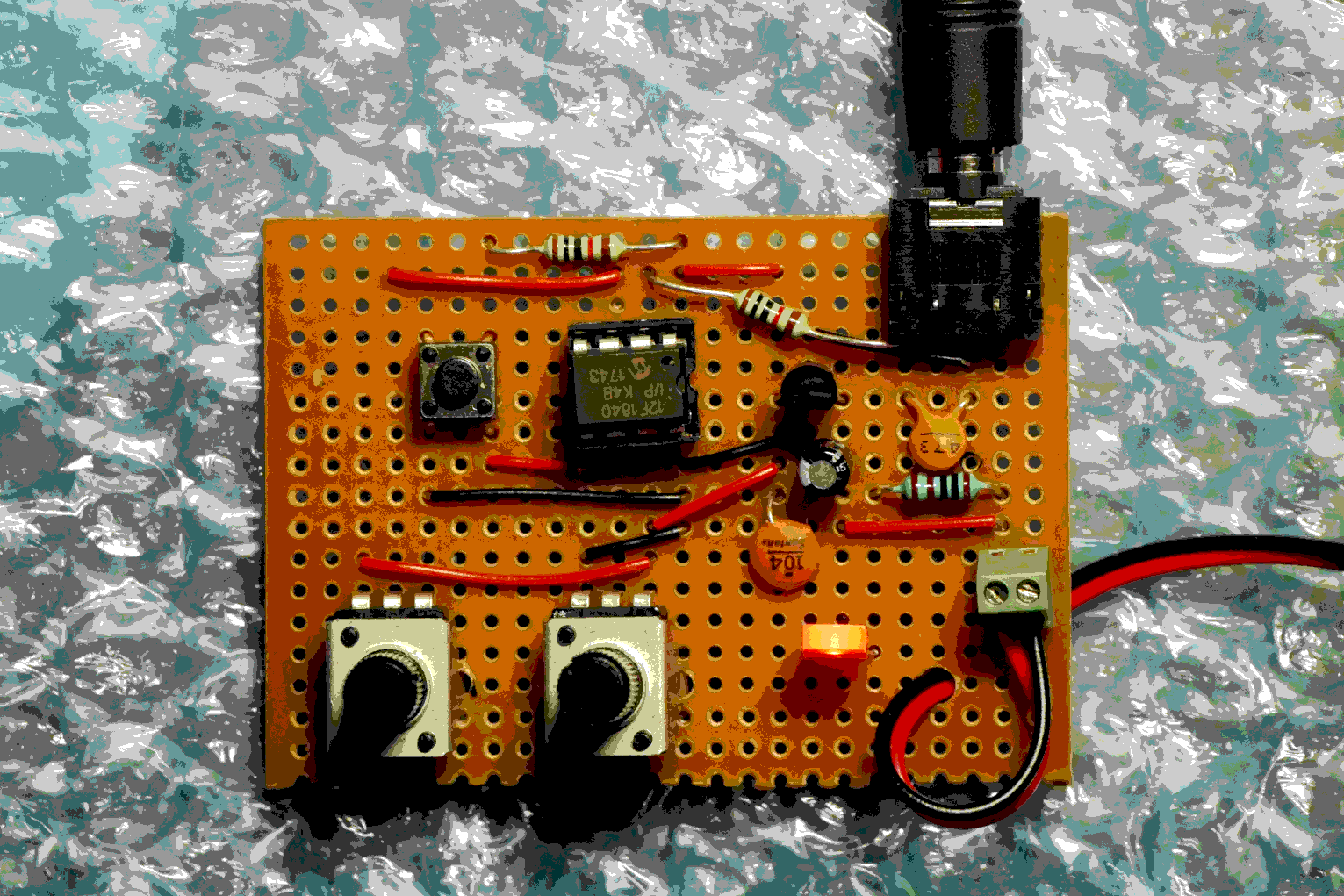 The original SNR. A small brown proto board with two knobs, a chip, button and led.