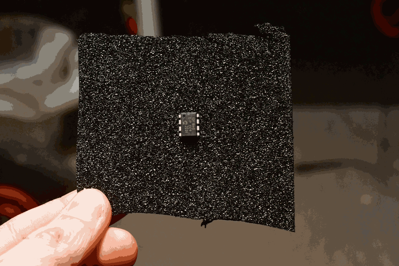 Radical chip. A chip in black foam. You can see a hand holding the foam.